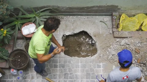 View from above of a worker removing the earth from a hole Stockbeeldmateriaal 150670022