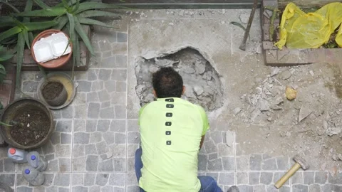 View from above of a workman breaking the floor of a house with a hammer Video stock 150669417