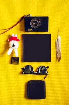 View from above. yellow background. notebook, toy, purse, pen, camera 스톡 사진
