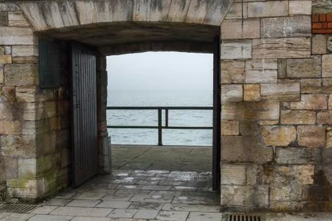 A view of access arch of stone and sea in the background, Portsmouth, UK Stock Photos