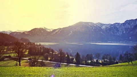 View across a grassy hillside of a tranquil lake Video stock 85311483