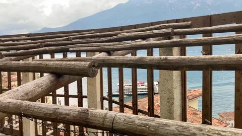 View across Lake Garda with ferry and lemon greenhouse in Limone sul Garda Stock Footage 329765797