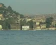 View across river of buildings and passing boat SD Footage