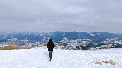 View aerial flight over mountain man walk cold blue nature snow landscape travel Video stock 105268935