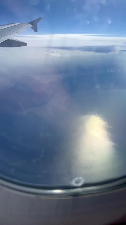 View from an aeroplane window flying over a sea Stock Footage 277084443