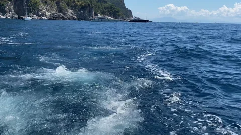 View from the aft deck of speedboat on water wake and powerful mountain cliffs Stock Footage 344655906