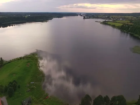 A view from the air to a small calm lake. Summer, green shores, clouds reflected Stock Footage 79647254