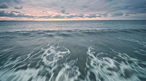 View from the air of the waves gently lapping the shore in the evening Stock Photos