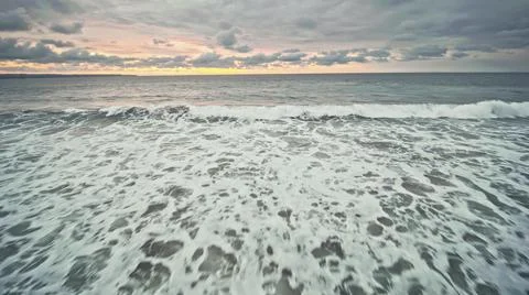 View from the air of the waves gently lapping the shore in the evening Stock Photos
