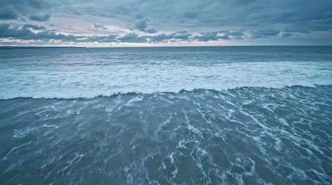 View from the air of the waves gently lapping the shore in the evening Stock Photos