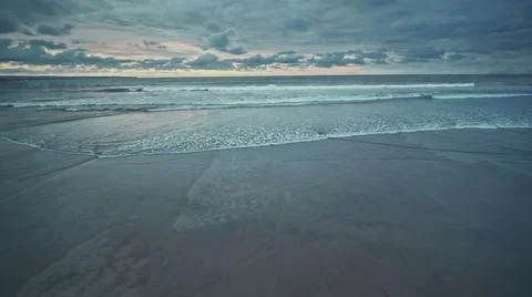 View from the air of the waves gently lapping the shore in the evening Stock Photos