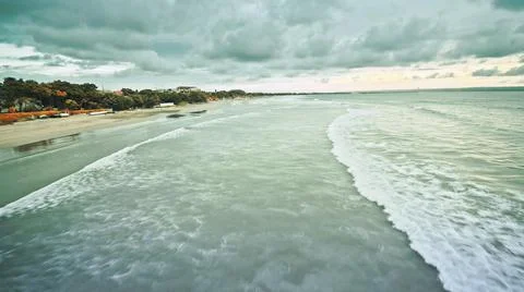 View from the air of the waves gently lapping the shore in the evening Stock Photos