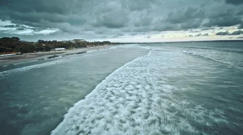 View from the air of the waves gently lapping the shore in the evening Stock Photos
