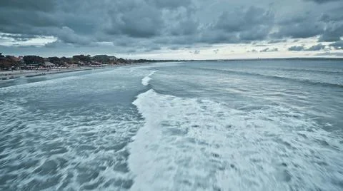 View from the air of the waves gently lapping the shore in the evening Stock Photos