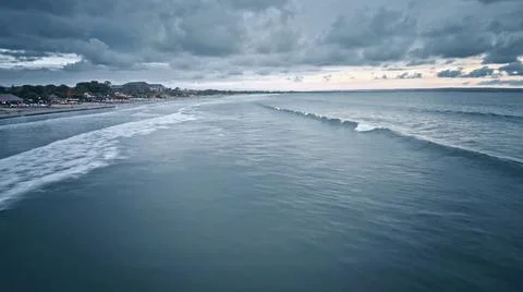 View from the air of the waves gently lapping the shore in the evening Stock Photos