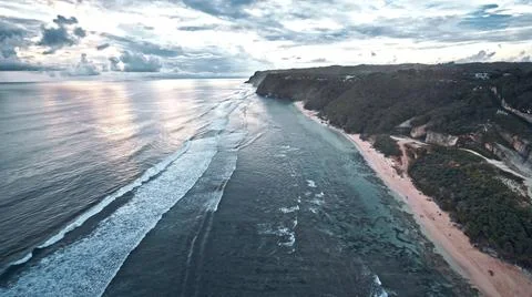 View from the air of the waves gently lapping the shore in the evening Stock Photos