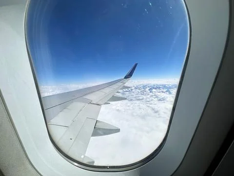 View to the aircraft wing from the window inside the plane Stock Photos