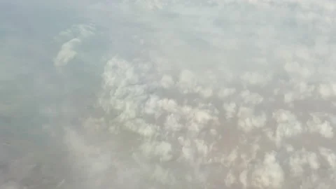 View from the airplane on clouds and the land - 4K, Sky background Stock Footage 174151399
