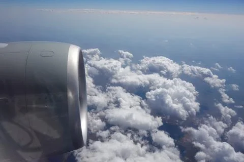 View of an airplane engine from a passenger window during flight above a layer o Foto stock