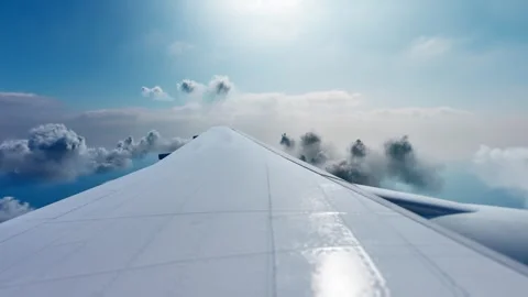 View of an airplane jet wing flying above white clouds and blue sky. Stock Footage 307514069
