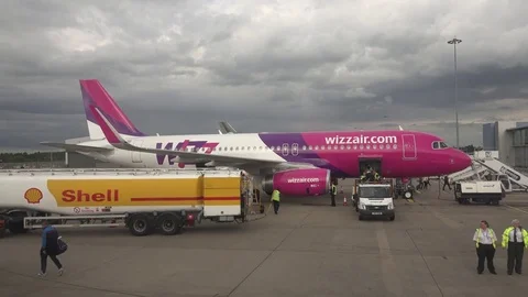 View of airplane loading and aircraft worker unloading luggage on airport piste Stock Footage 81986874
