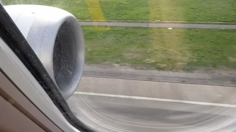 View of an airplane turbine from a window during landing with runway visible Stock Footage 339353974