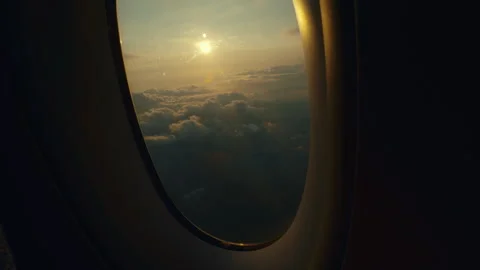 View from airplane window above clouds during colorful sunset sky Stock-Footage 330963312