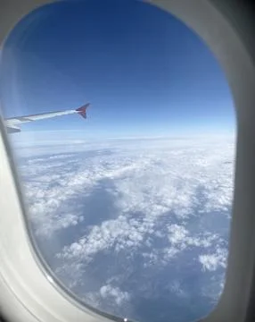 View from Airplane Window Above the Clouds Stock-Fotos