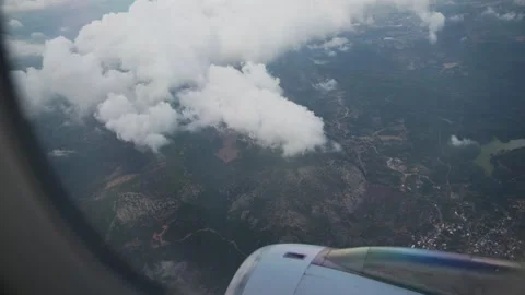 View from Airplane Window as Aircraft Turns and Mountains Appear Below Видео 346105877