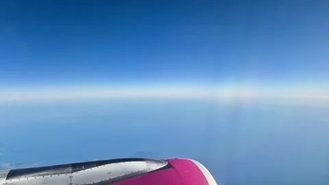 View from airplane window with aircraft wing above clouds and blue sky. Air trav Stock Footage 332985969