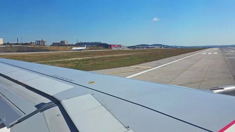 View from airplane window of aircraft wing above runway as plane taxis towa.. Video stock 342065333