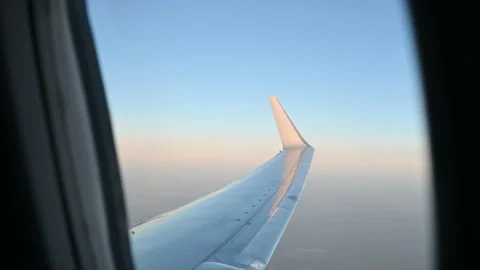 View of airplane window and wing against sunset sky Vídeo Stock 149106687