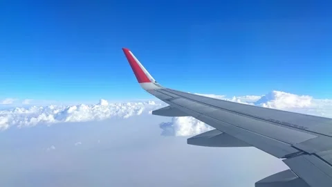 View from the airplane window at a beautiful cloudy sky and the airplane wing. Stock Footage 305591563