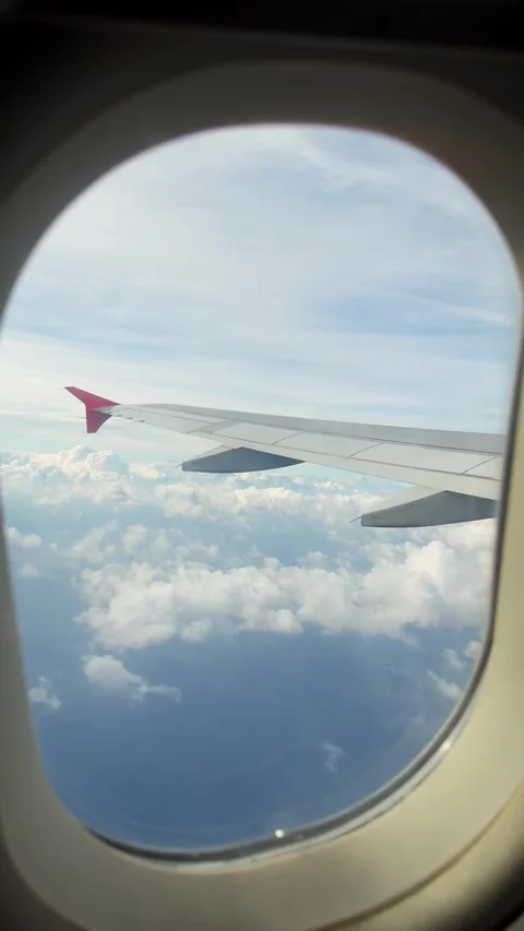 View from airplane window at beautiful fluffy clouds. Travel concept, vertical Stock Footage 303505070