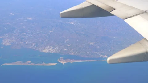View From Airplane Window at Beautiful ocean and coastline in 4k slow motion Vídeo Stock 148076810