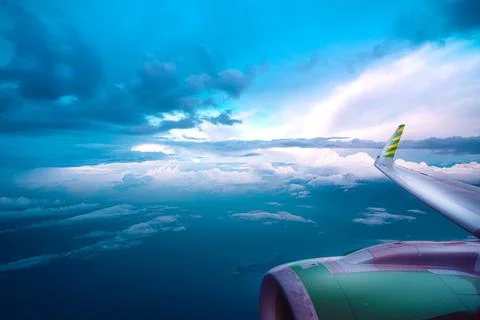 View from the airplane window on a beautiful sunset above the clouds. Stock Photos