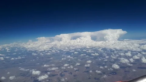 View from the airplane window to the blue sky and white clouds, a view of the Stock Footage 88128143