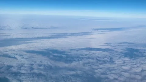 View from an airplane window to a cloud-covered landscape Stock Footage 267578877