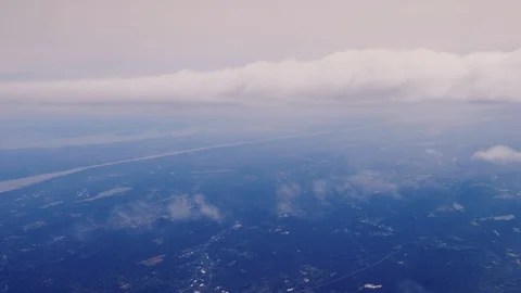The view from the airplane window is clouds and the earth is far below Stock Footage 87696754