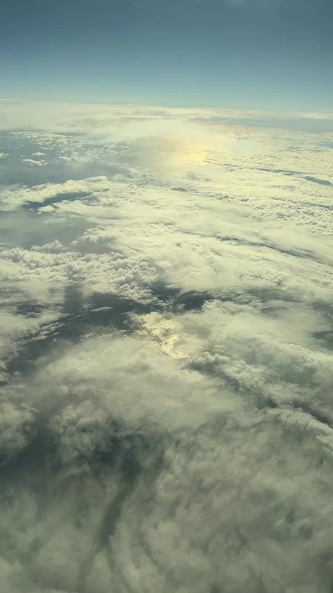 View from airplane window with clouds and sunlight above sky Stock Footage 320312705