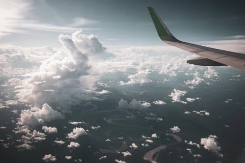 View from the airplane window of clouds and earth, Amazon river, bleached colors Stock Photos