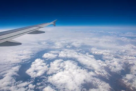 View from an airplane window on clouds and blue sky Stock Photos