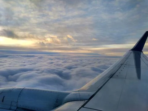 View from the airplane window to the clouds and sun Stock Photos