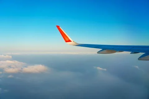The view from the airplane window to the clouds and sunset. Airplane wing abo 写真素材