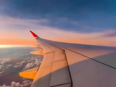 The view from the airplane window to the clouds and sunset during a flight 스톡 사진