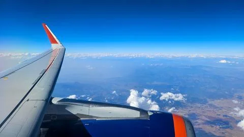 View from airplane window with clouds and blue sky Stock Photos