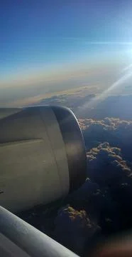 A view from an airplane window of clouds and bright sun 스톡 사진