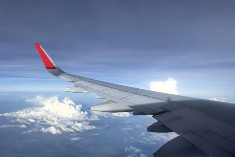 View from the airplane window on clouds, blue clear sky. Look seen through Stock Photos