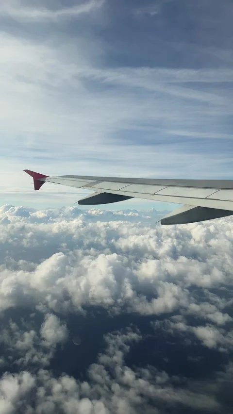 View from the airplane window to the clouds, the plane flies over the sea 스톡 동영상 297772787