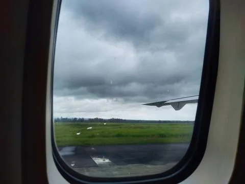 View from airplane window covered with cloudy sky and raindrops. Stock Photos